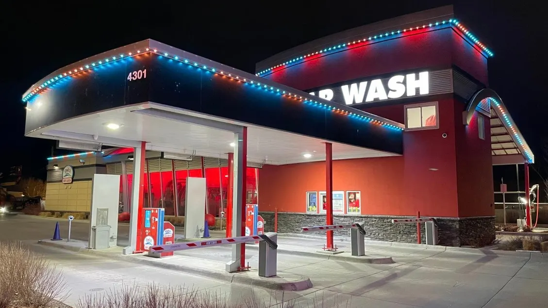 Car wash building with red and blue permanent lights along the roofline