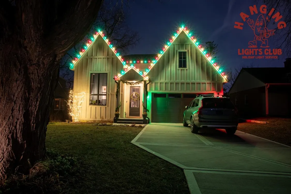 Modern home with red and green holiday lights on the roofline and garage