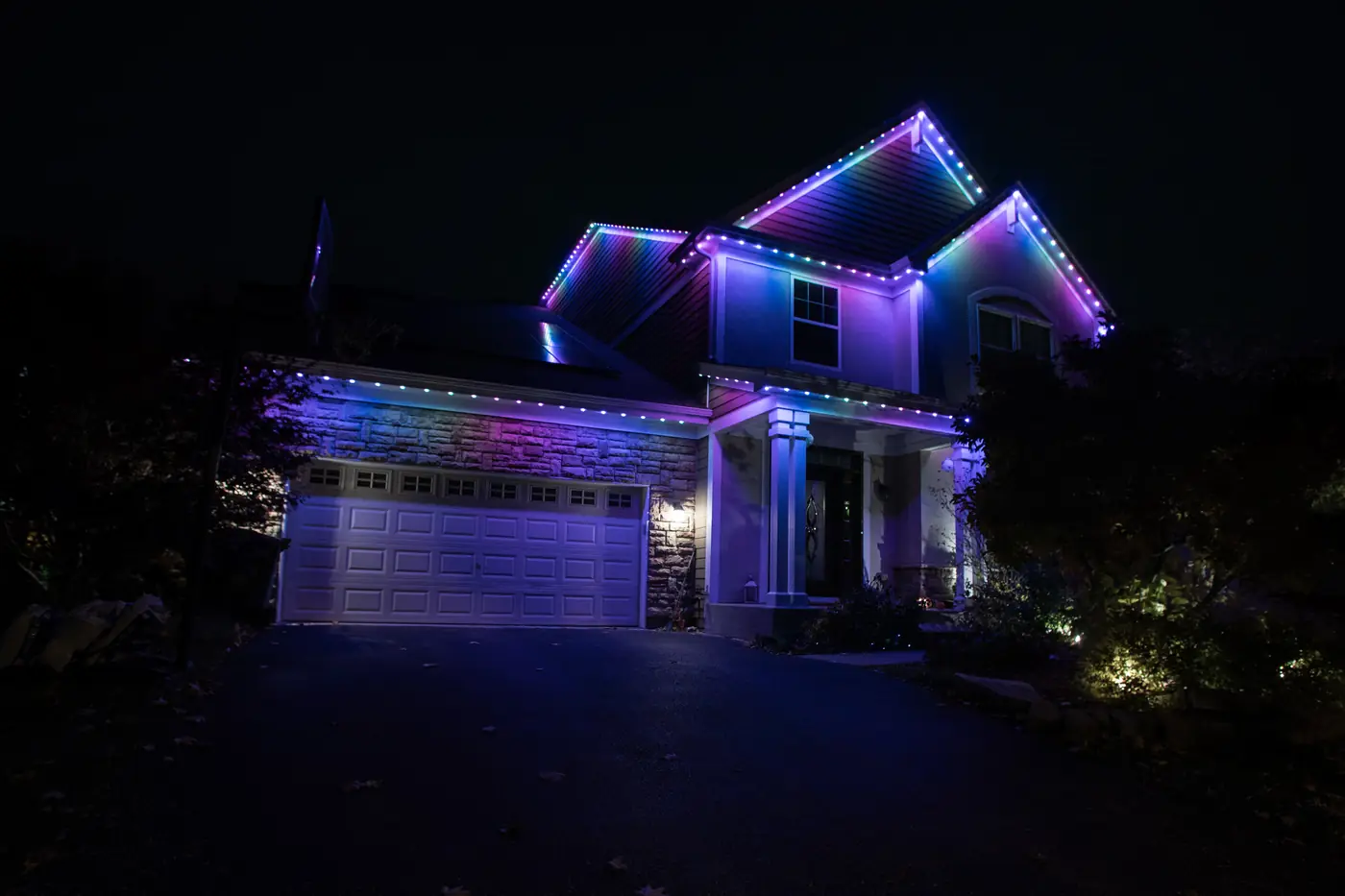 Chicagoland home at night with a full color permanent roofline lighting system running a seasonal color scene